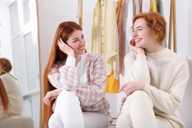 Photo of Portrait of beautiful young redhead sisters in dressing room