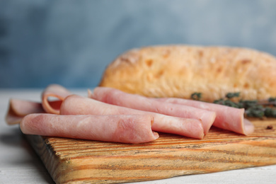 Photo of Tasty ham on white wooden table, closeup