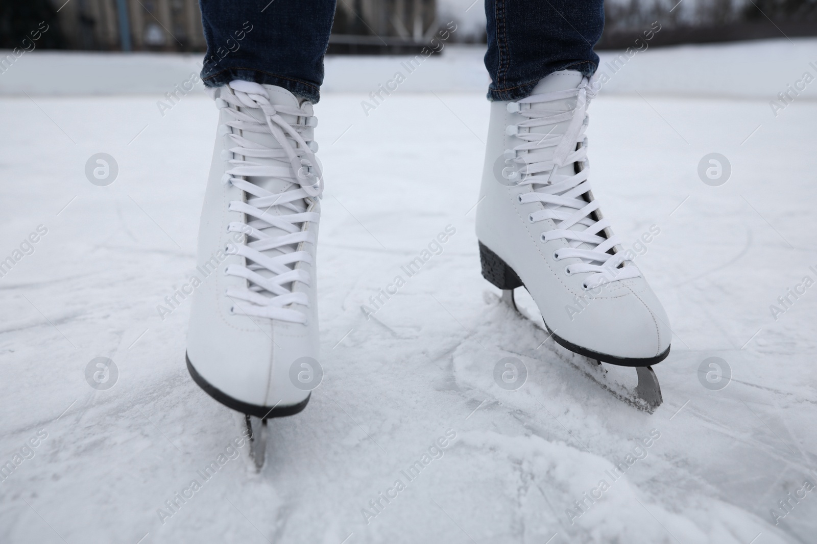 Photo of Woman wearing figure skate on ice rink, closeup