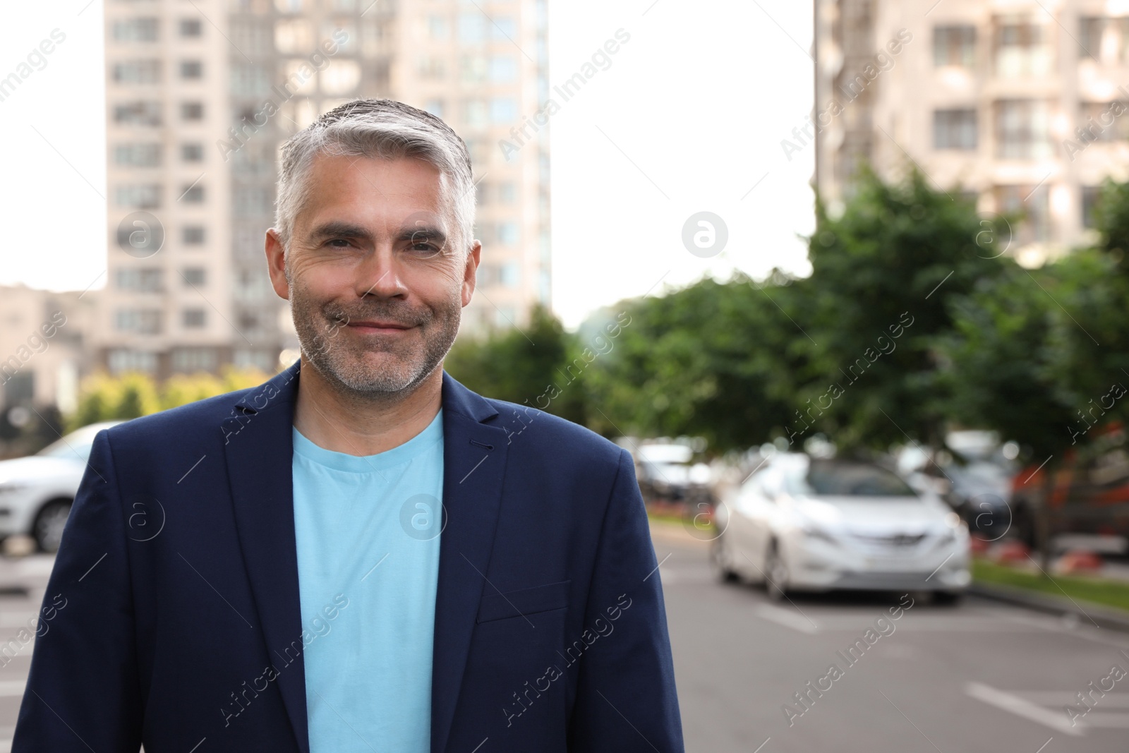 Photo of Portrait of handsome mature man in city center. Space for text