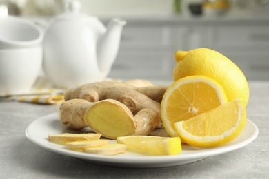 Fresh lemons and ginger on grey table indoors, closeup