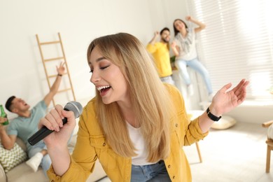 Young woman singing karaoke with friends at home