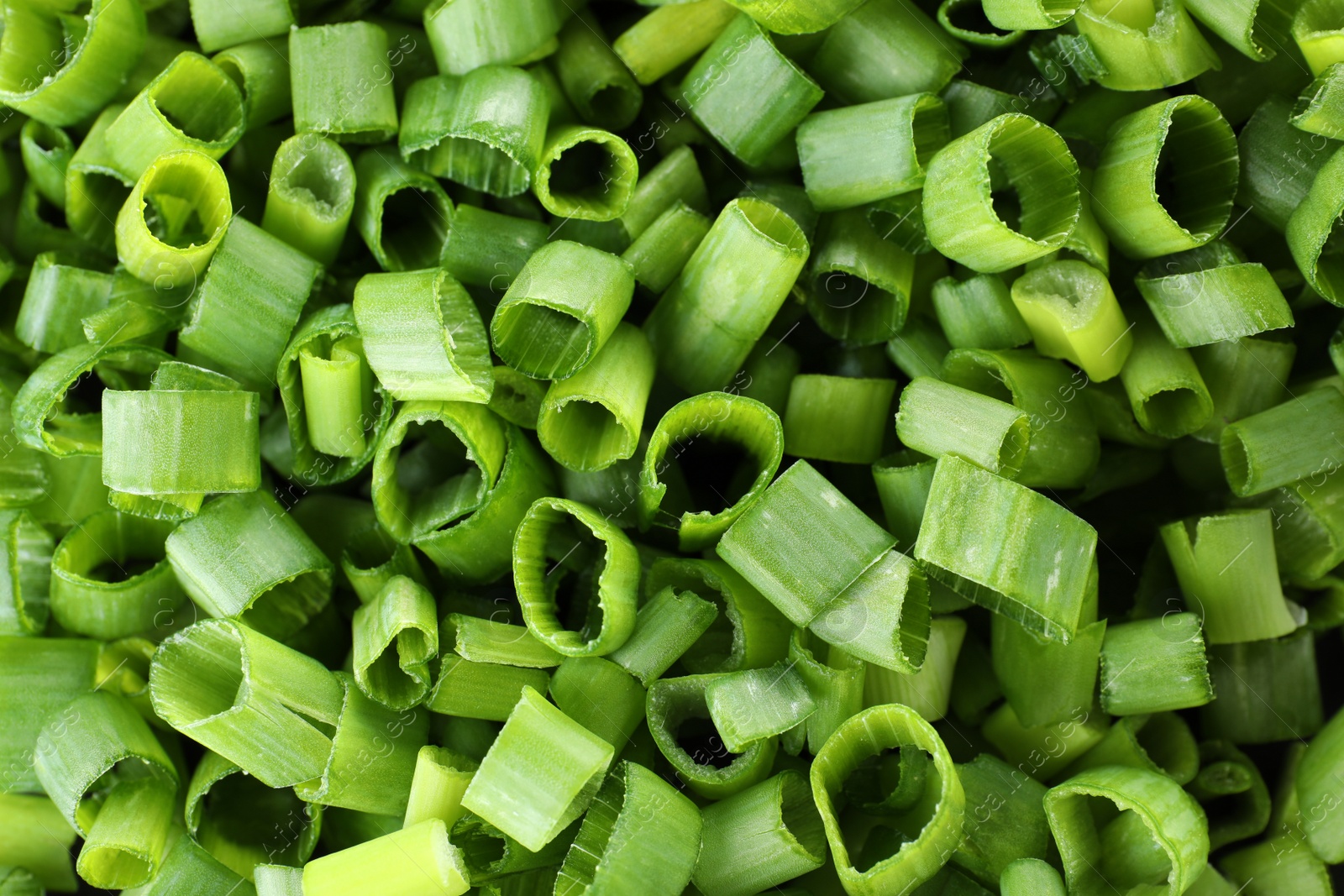 Photo of Cut fresh green onions as background, top view