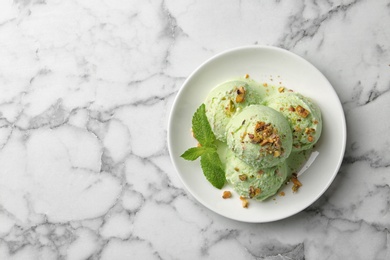 Photo of Delicious pistachio ice cream on marble table, top view. Space for text