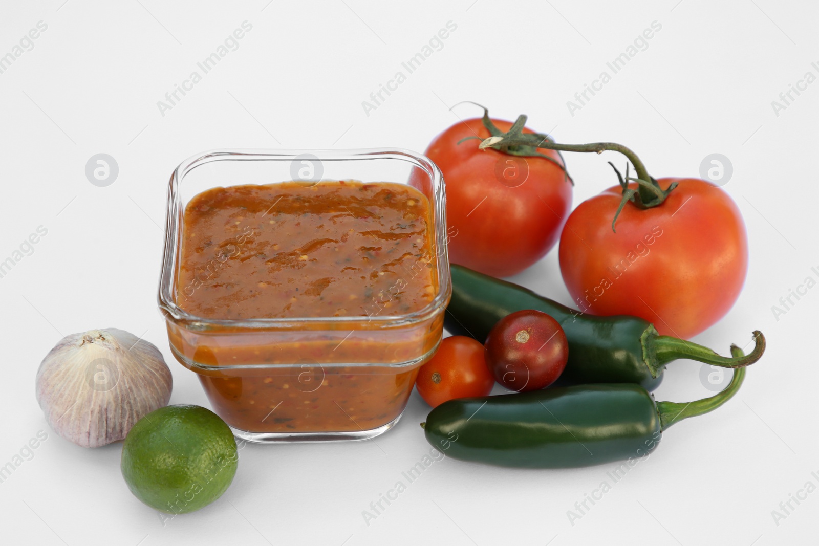 Photo of Delicious salsa sauce and ingredients on white background