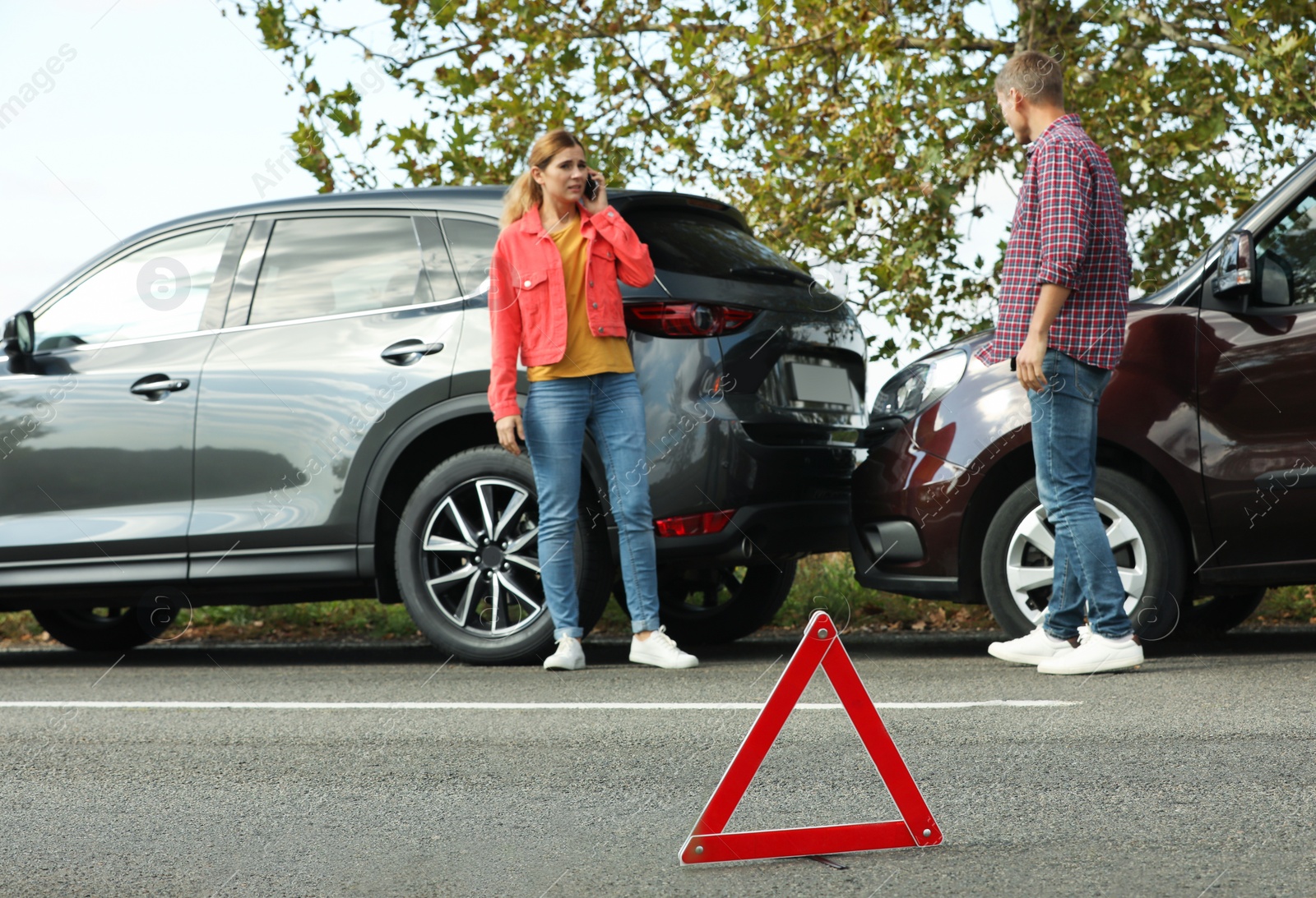 Photo of Emergency stop sign near people discussing car accident on road. Auto insurance