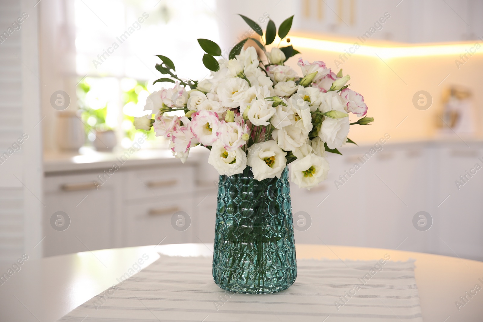 Photo of Bouquet of beautiful flowers on table in kitchen. Interior design