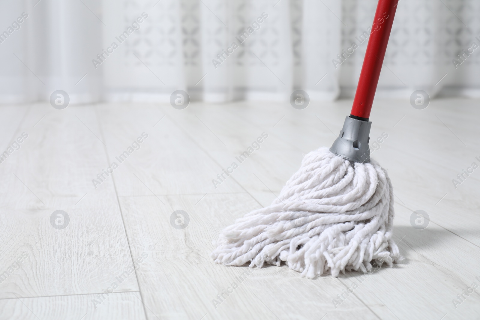 Photo of Cleaning dirty parquet floor with mop indoors. Space for text