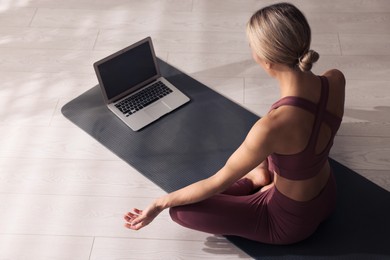 Photo of Woman watching online yoga class at home