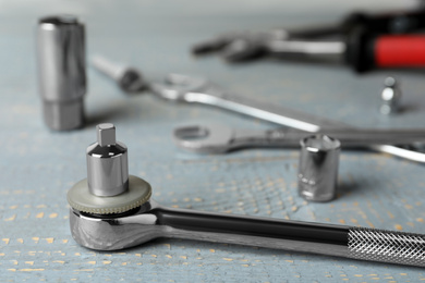 Auto mechanic's tool on grey wooden table, closeup