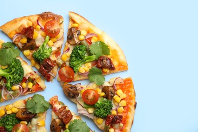 Photo of Delicious vegetarian pizza with mushrooms, vegetables and parsley on light blue background, top view. Space for text