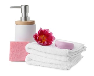 Soap bars, dispenser and stack of terry towels on white background