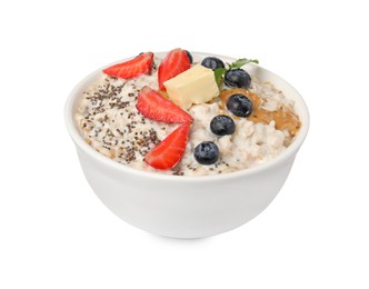 Photo of Tasty boiled oatmeal with berries, chia seeds and peanut butter in bowl isolated on white