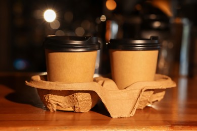 Paper coffee cups on wooden table in cafe