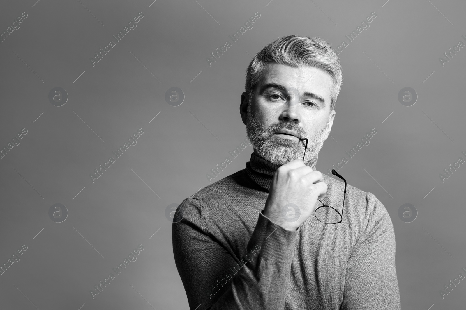 Photo of Portrait of handsome man on grey background, space for text. Black and white effect