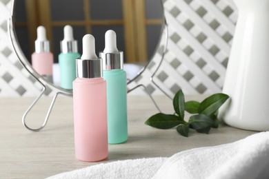 Bottles of serum on wooden table, space for text. Cosmetic products