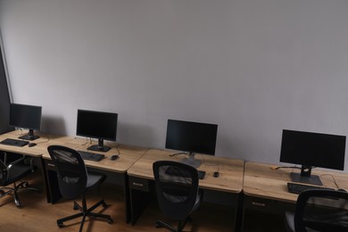 Photo of Row of modern computers in open space office, above view