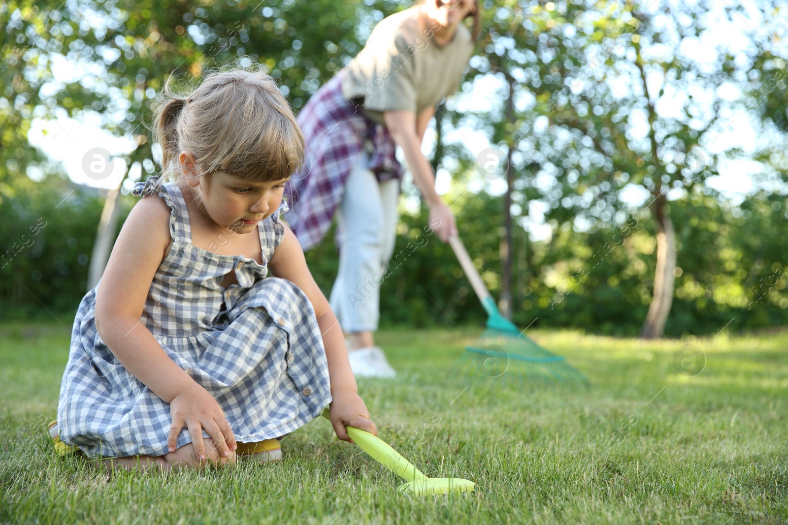 Photo of Mother and her daughter working together in garden