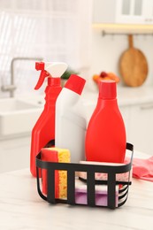 Different cleaning supplies in basket on table