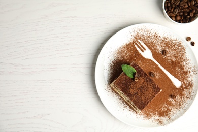 Flat lay composition with tiramisu cake  on white table, space for text