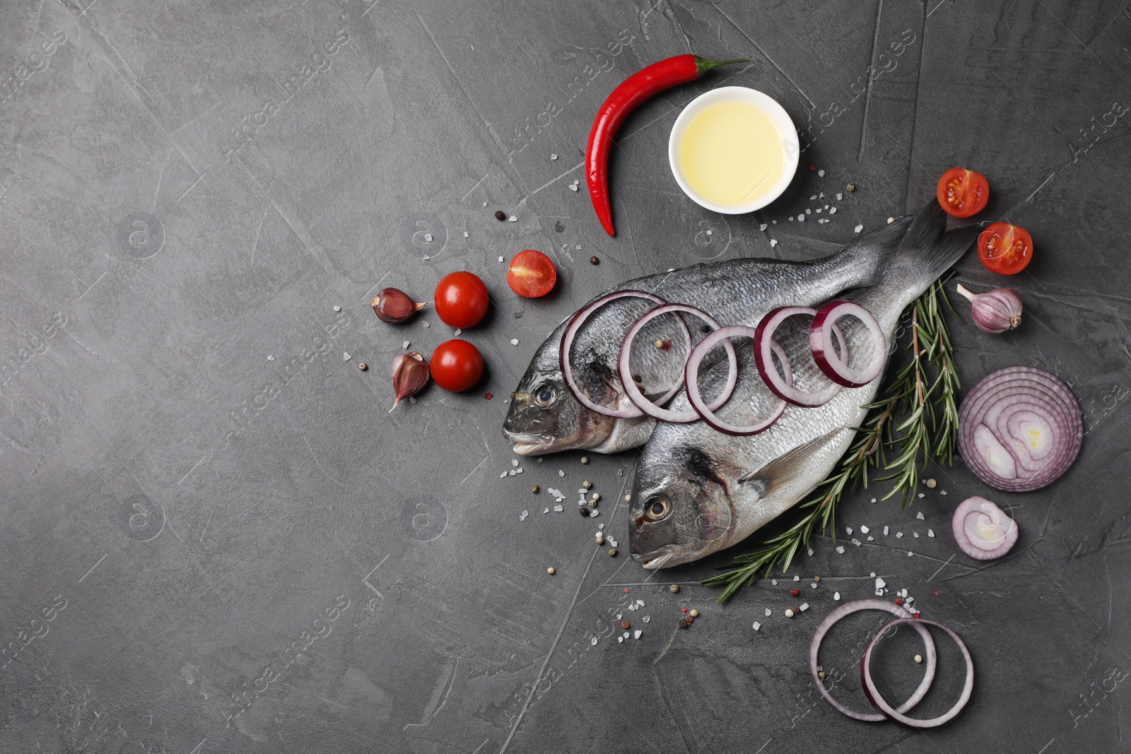 Photo of Fresh dorado fish and ingredients on grey table, flat lay. Space for text