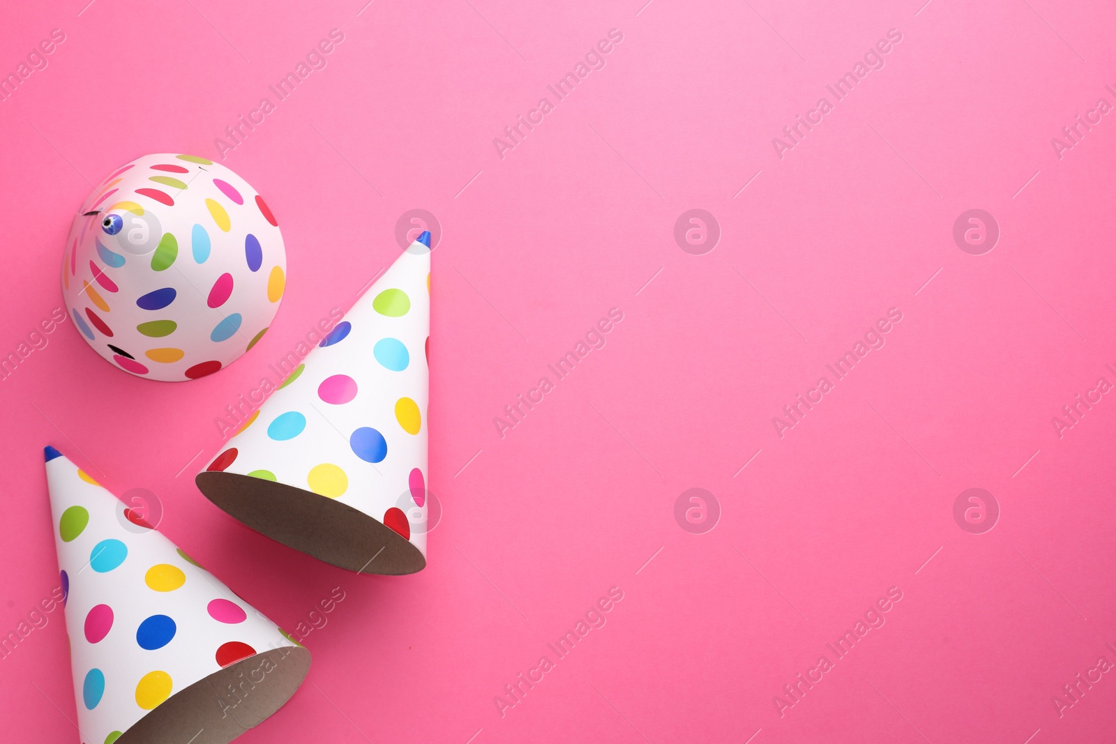 Photo of Beautiful party hats on pink background, top view. Space for text