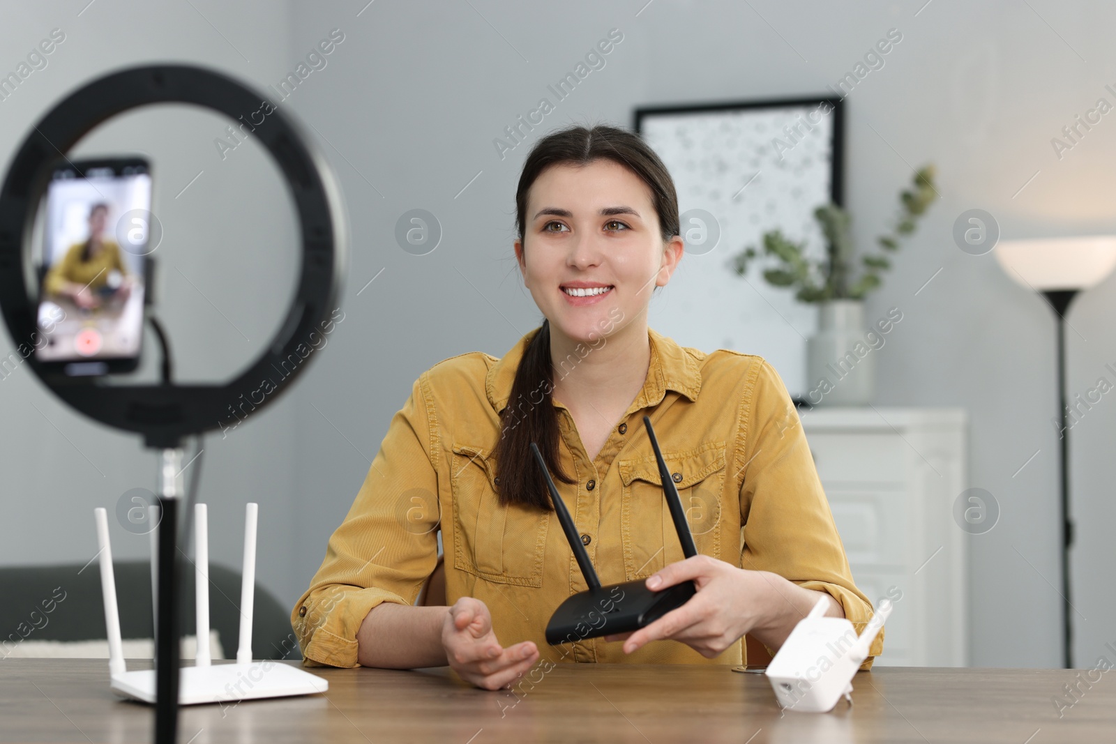 Photo of Smiling technology blogger recording video review about WI-FI devices at home