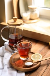 Photo of Delicious tea, sugar and lemon on wooden table