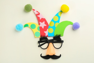 Photo of Flat lay composition with clown's face made of party glasses and hat on white background