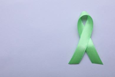 World Mental Health Day. Green ribbon on color background, top view with space for text