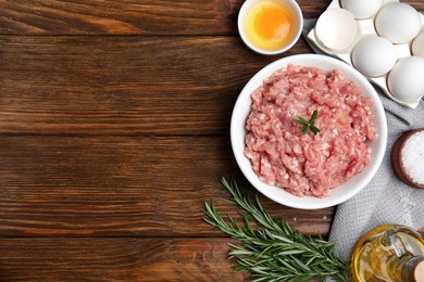 Photo of Raw chicken minced meat and ingredients on wooden table, flat lay. Space for text