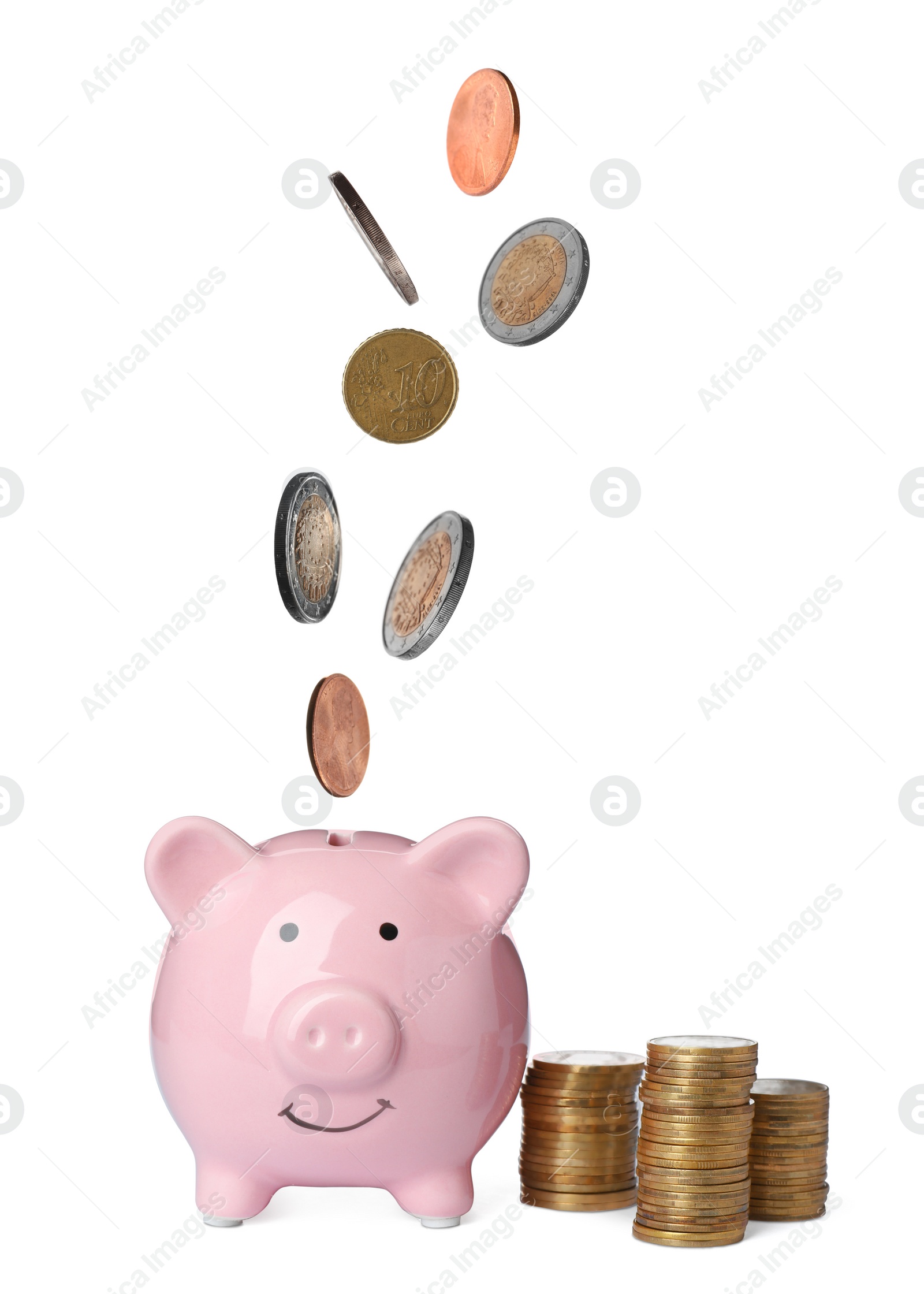 Image of Different coins falling into cute piggy bank on white background