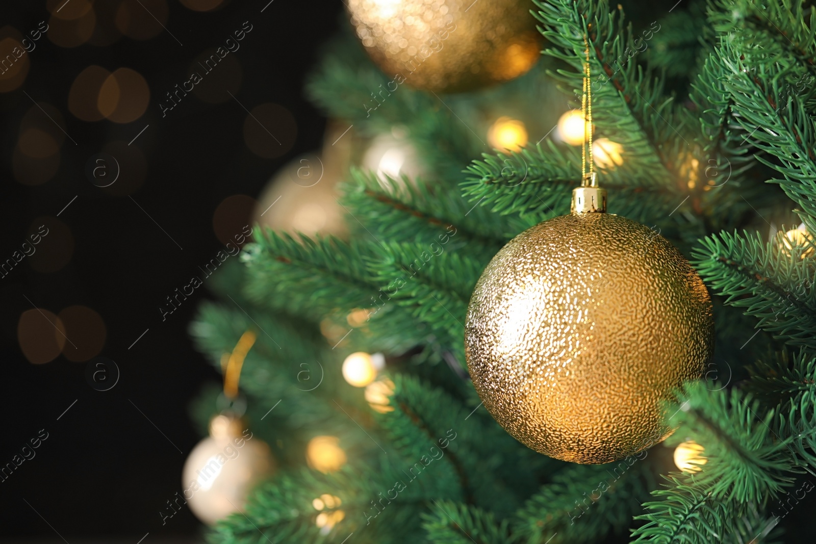 Photo of Beautiful Christmas tree with festive decor against blurred lights on background, closeup