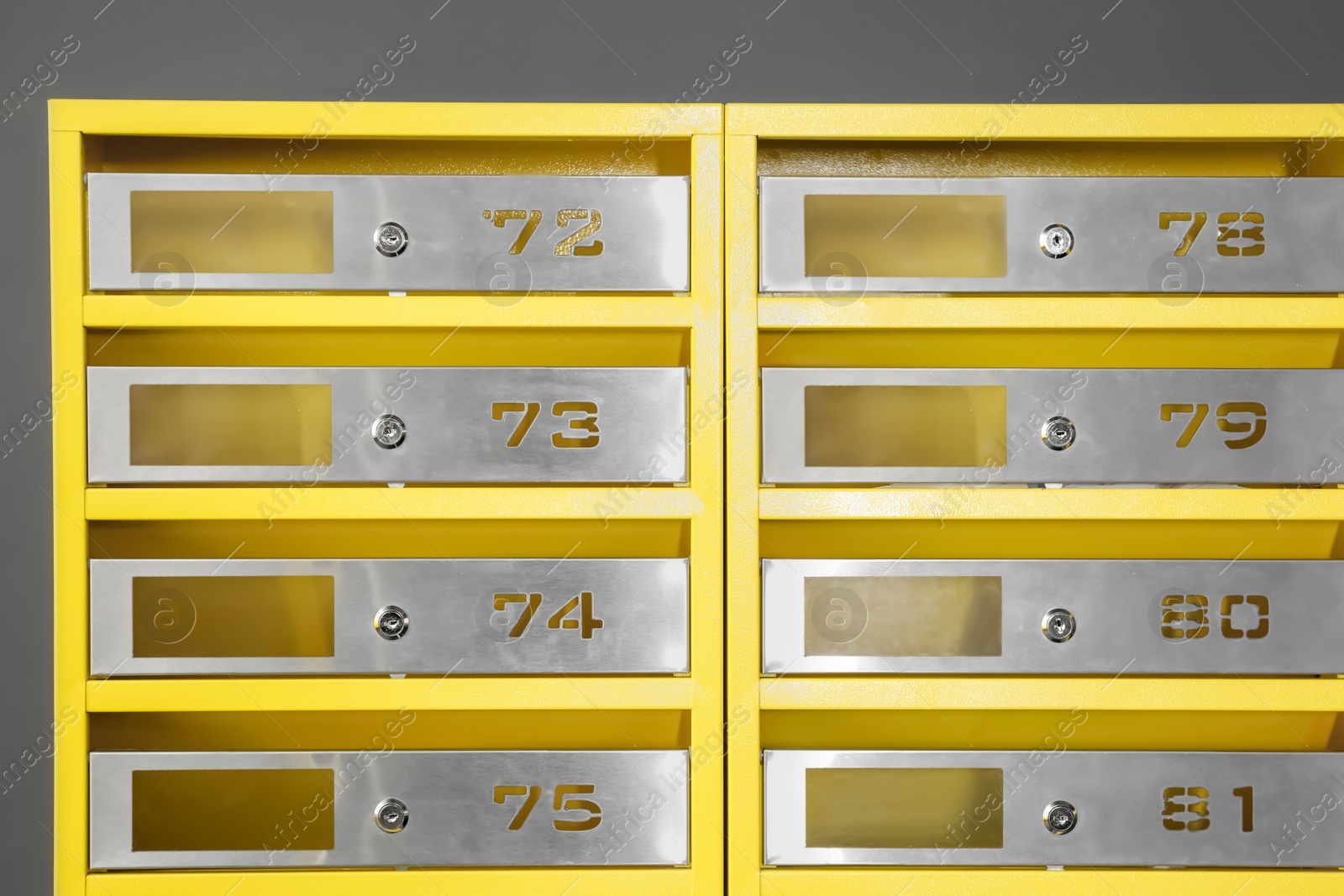 Photo of Many closed metal mailboxes with keyholes and numbers in post office