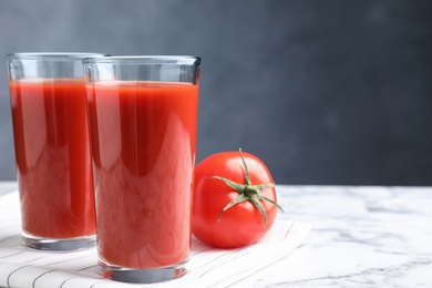 Delicious fresh tomato juice on white marble table, closeup. Space for text