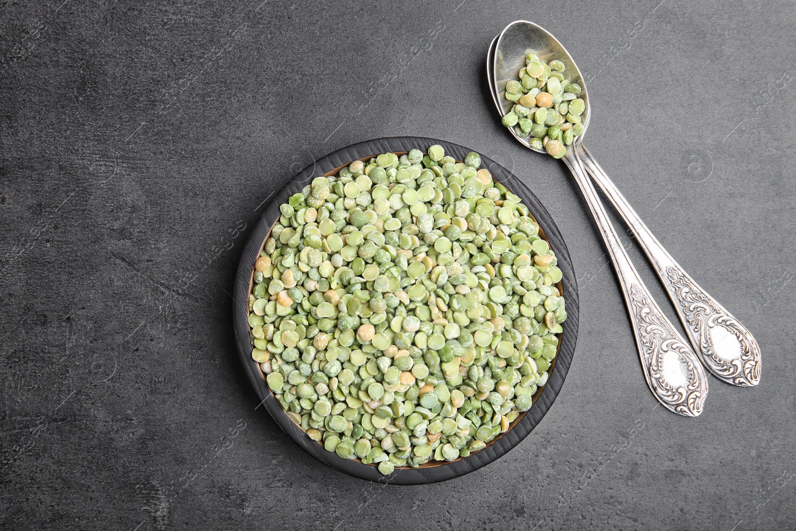 Photo of Plate and spoons with dried peas on grey background, top view