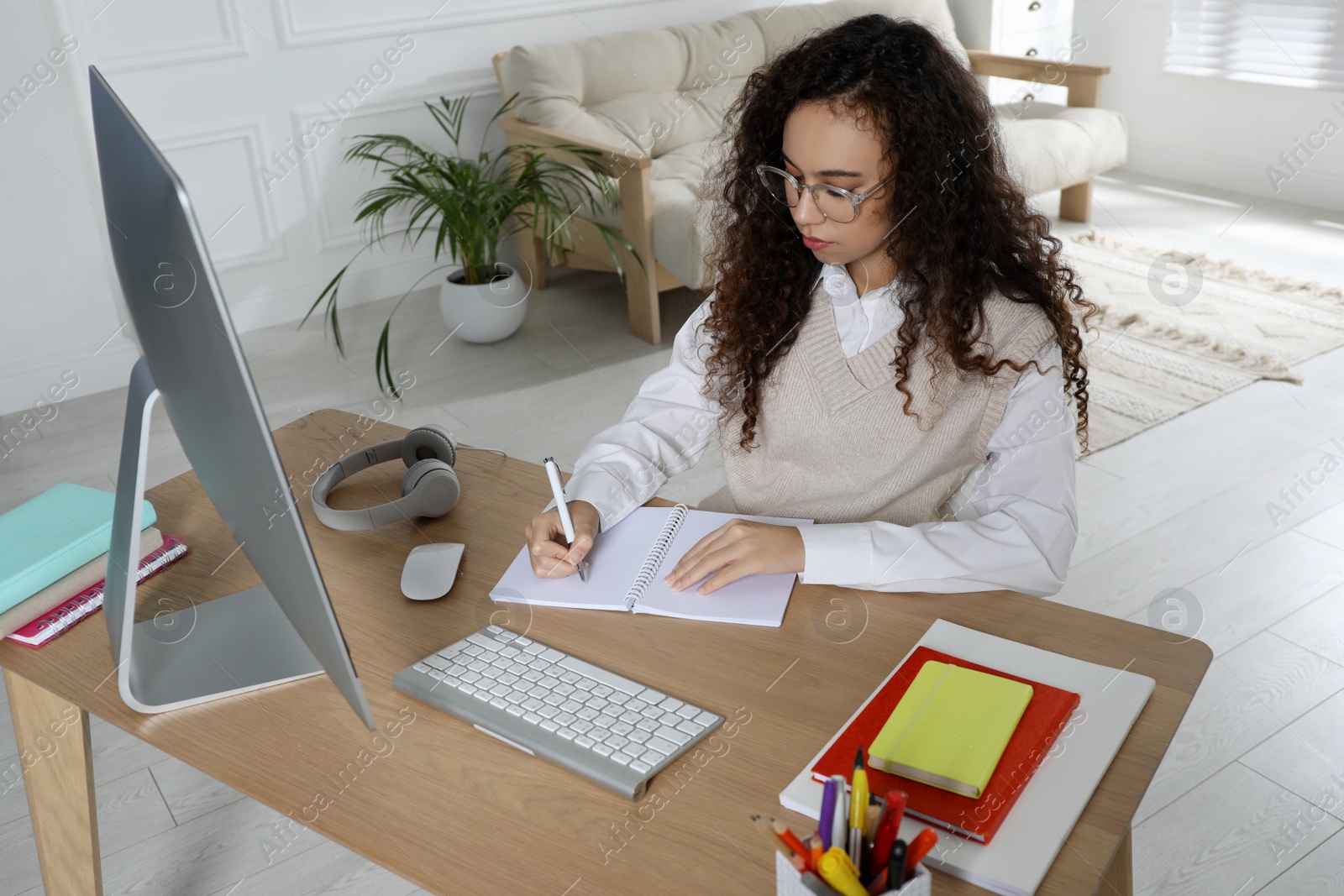 Photo of African American woman using modern computer for studying at home. Distance learning