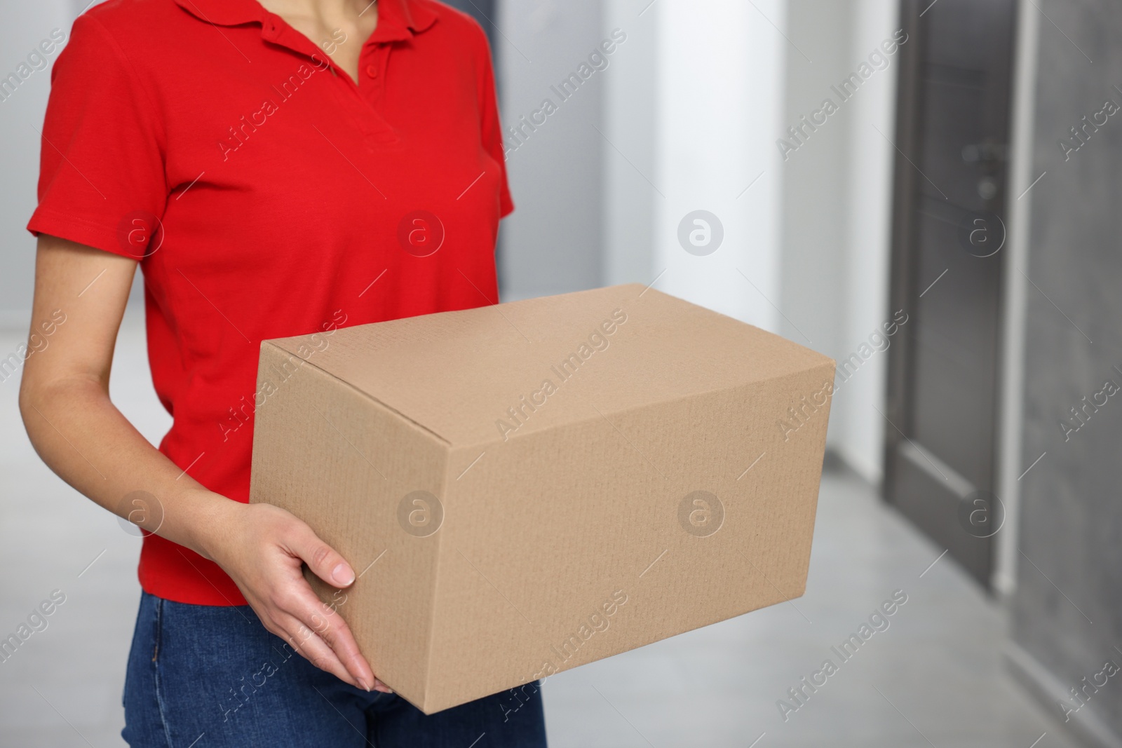 Photo of Courier with cardboard boxes in hallway, closeup