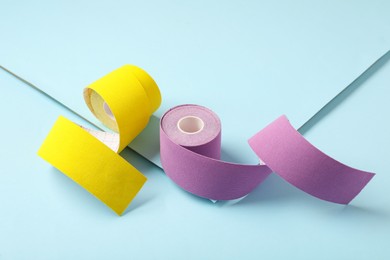 Bright kinesio tape in rolls on light blue background