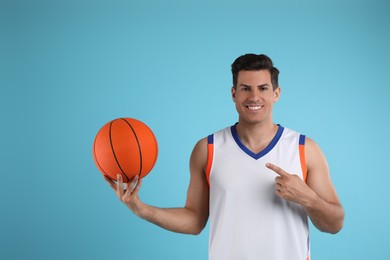 Photo of Basketball player with ball on light blue background