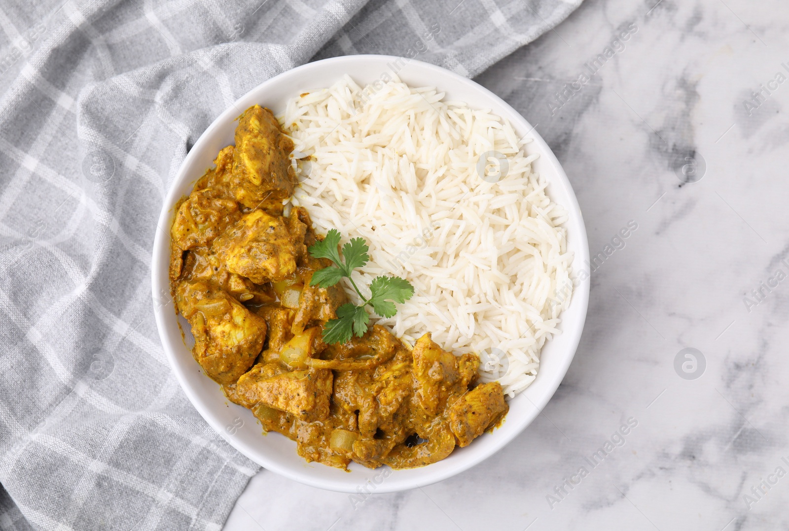 Photo of Delicious chicken curry with rice on white marble table, top view