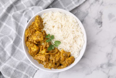 Photo of Delicious chicken curry with rice on white marble table, top view