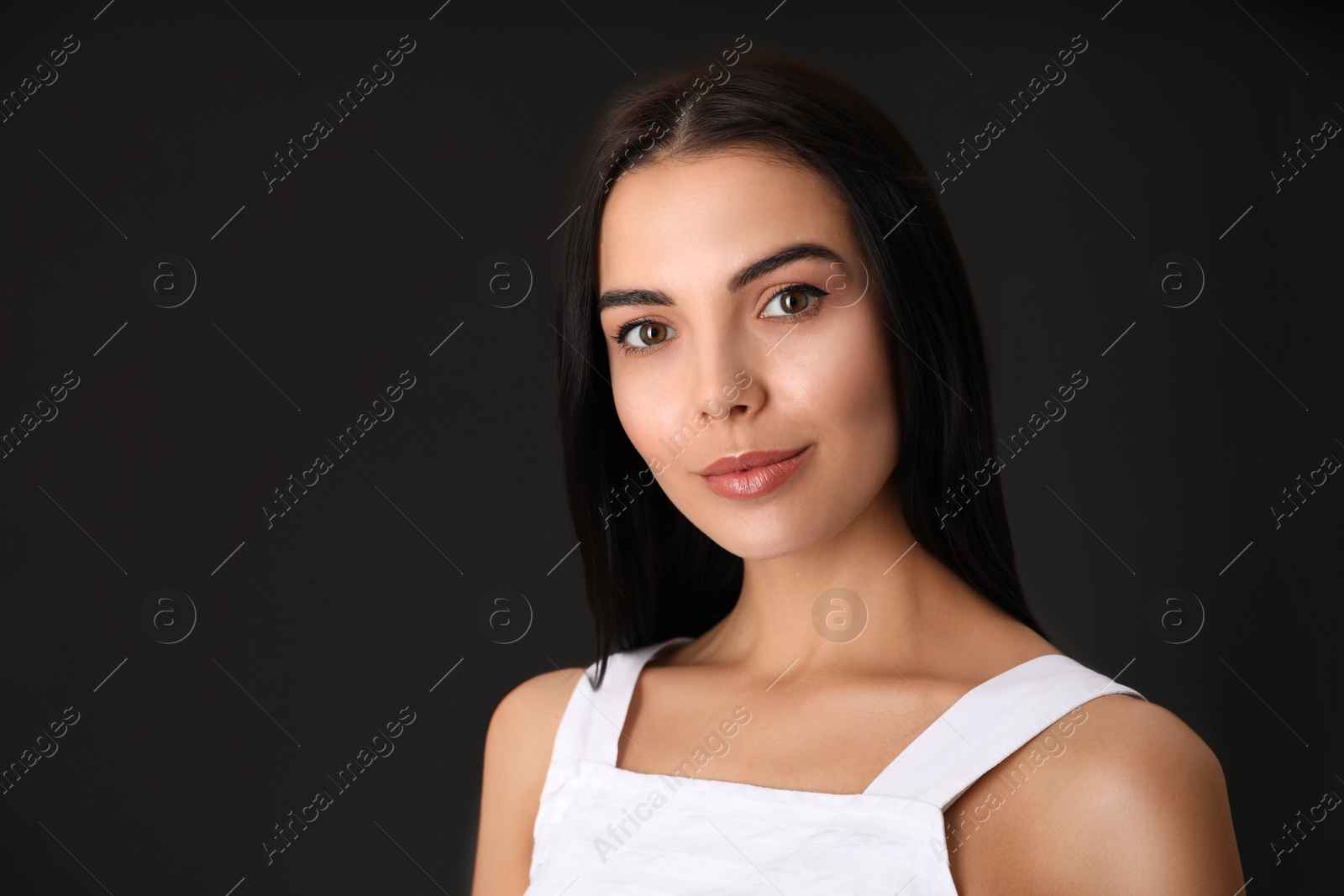 Photo of Portrait of beautiful young woman on dark grey background