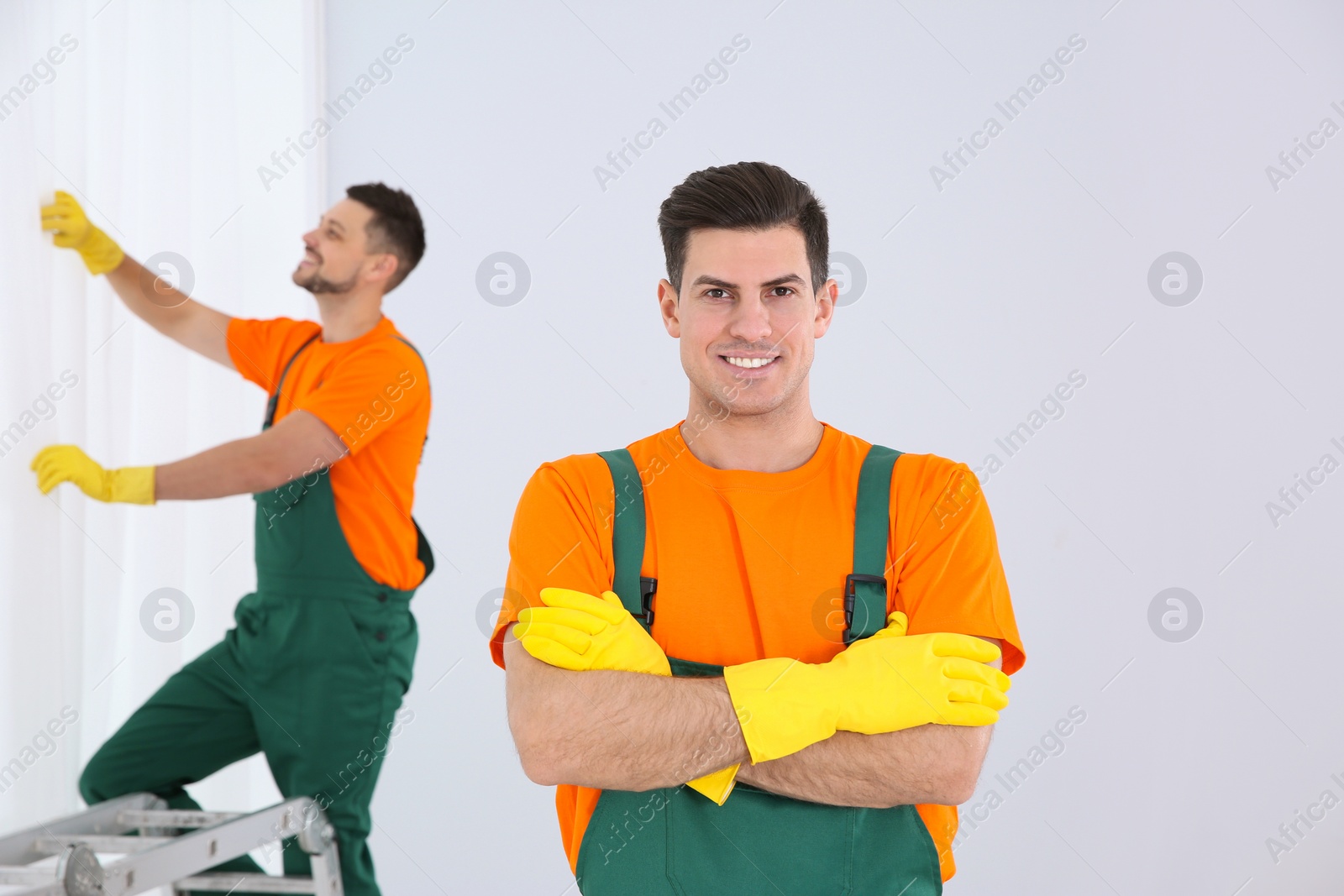 Photo of Team of professional janitors cleaning room after renovation