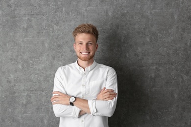 Photo of Portrait of handsome young man near grey wall