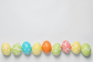 Photo of Colorful painted Easter eggs on white background, top view