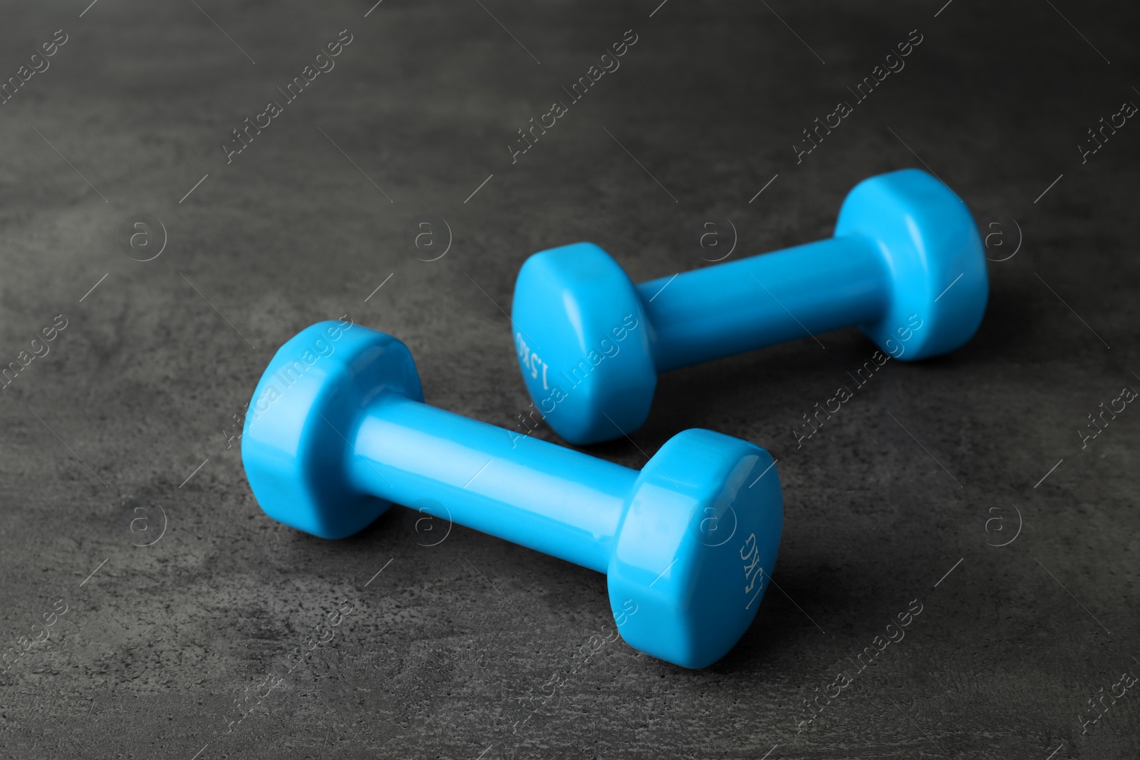 Photo of Light blue vinyl dumbbells on grey table