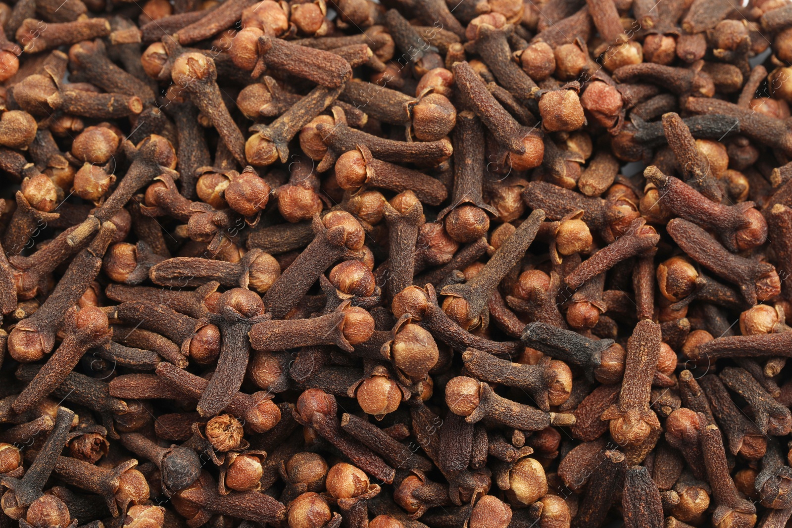 Photo of Aromatic dry cloves as background, top view