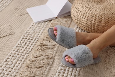 Woman wearing grey soft slippers indoors, closeup