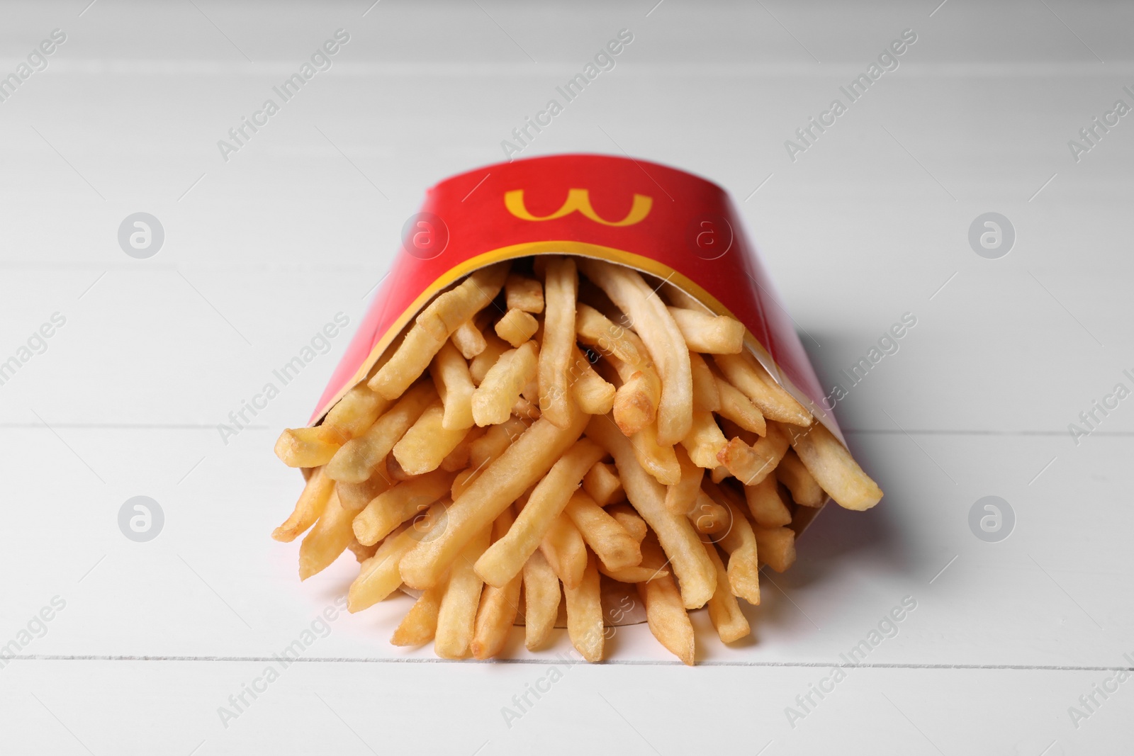 Photo of MYKOLAIV, UKRAINE - AUGUST 12, 2021: Big portion of McDonald's French fries on white wooden table